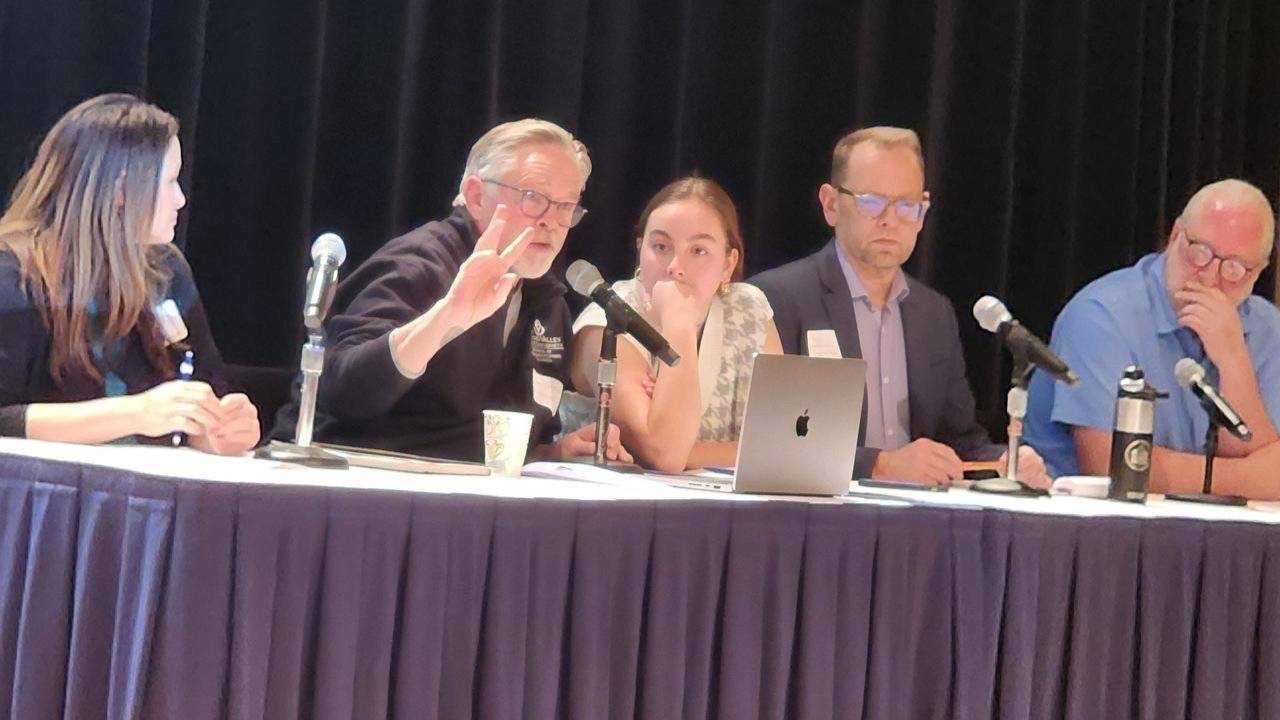 panelists at a long table on a stage